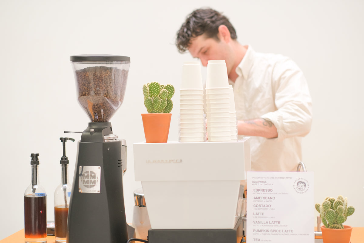 Person working with coffee equipment and ingredients in a kitchen setting